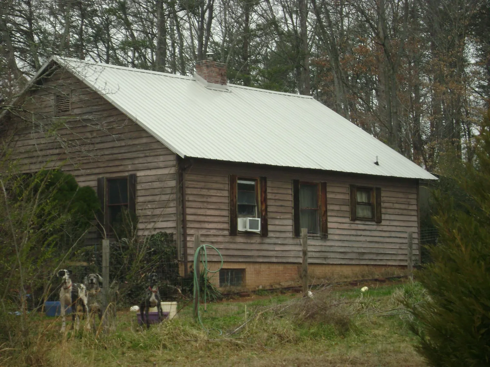 White metal roof on an old wood sided farmhouse, from a Asphalt Shingle Roof Repair job in North Port